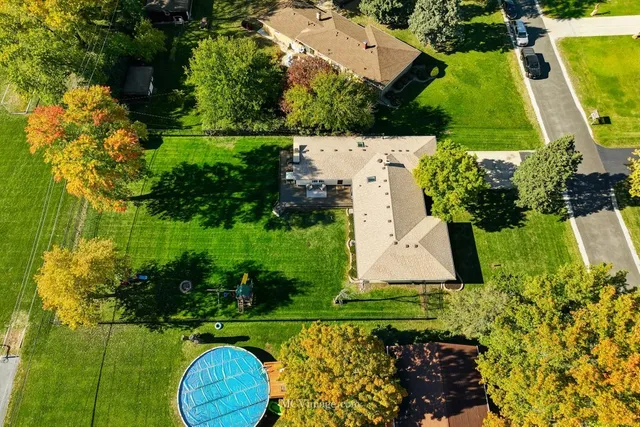 an aerial view of a house with a yard and swimming pool