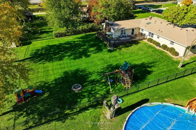 an aerial view of a house with pool yard and outdoor seating