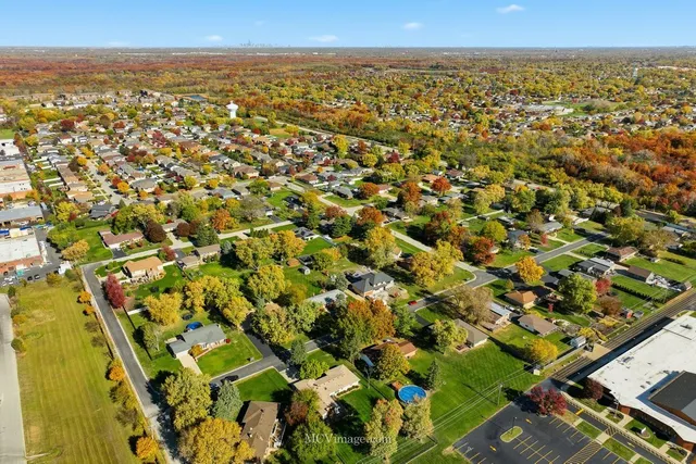 an aerial view of residential houses with outdoor space and trees