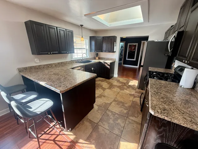 a kitchen with a sink refrigerator and cabinets