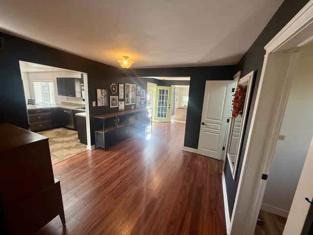 a view of a livingroom with wooden floor and furniture