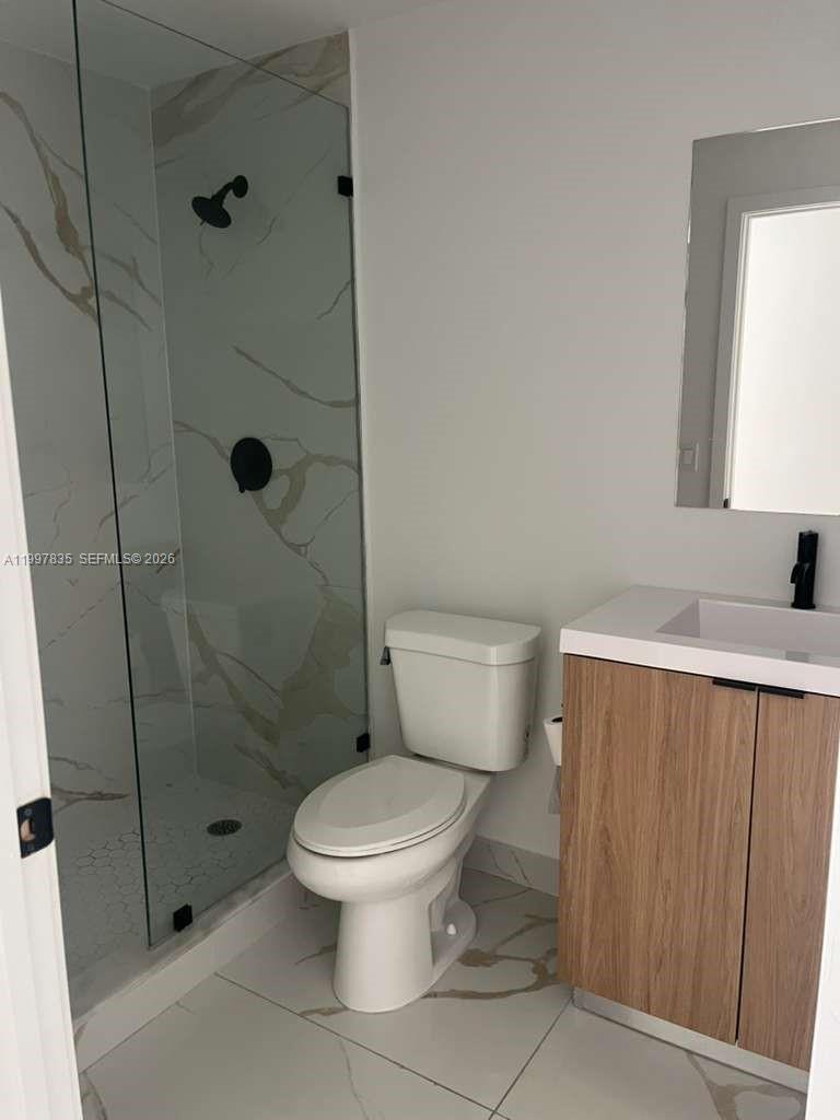 14561 Southwest 261st Terrace, Unit 1 Homestead, FL 33032 - Photo 4 of 13 a white toilet sitting next to a shower