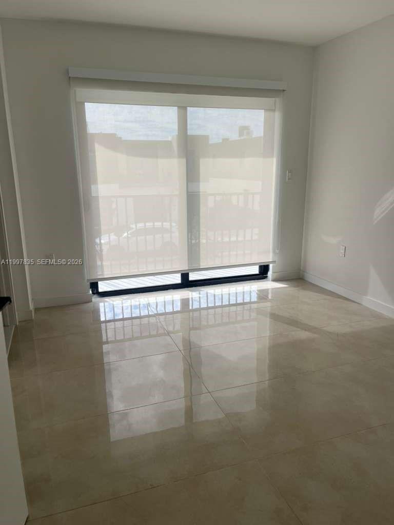 14561 Southwest 261st Terrace, Unit 1 Homestead, FL 33032 - Photo 6 of 13 a view of an empty room with a window