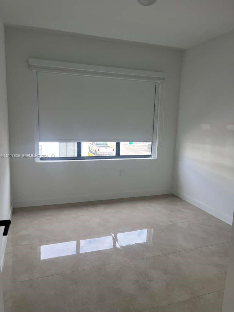 14561 Southwest 261st Terrace, Unit 1 Homestead, FL 33032 - Photo 7 of 13 an empty room with a window