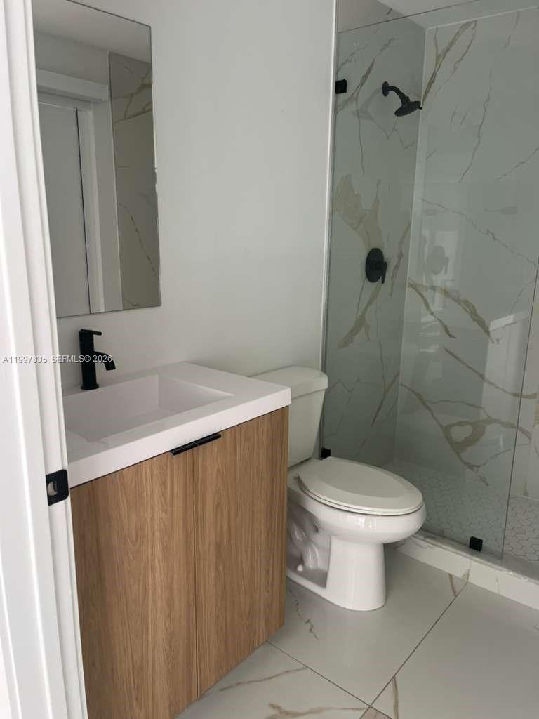 14561 Southwest 261st Terrace, Unit 1 Homestead, FL 33032 - Photo 8 of 13 a bathroom with a sink a toilet and shower