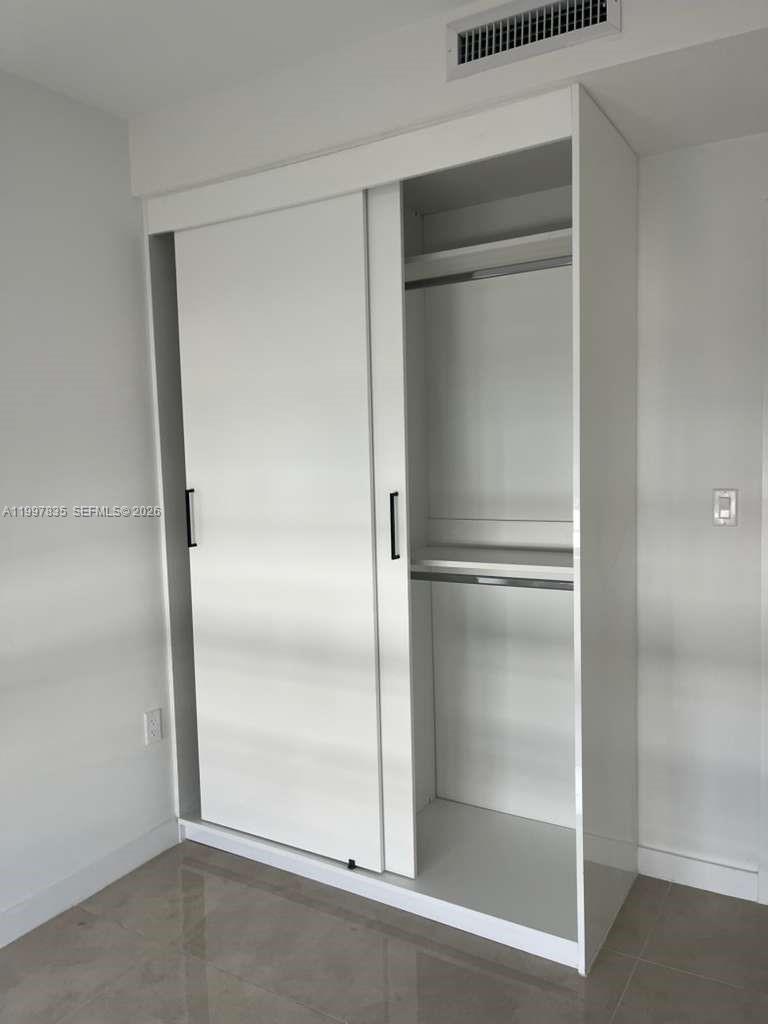 14561 Southwest 261st Terrace, Unit 1 Homestead, FL 33032 - Photo 10 of 13 a bathroom with a glass shower door