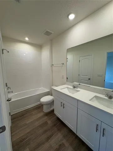 a bathroom with a double vanity sink toilet and a bathtub