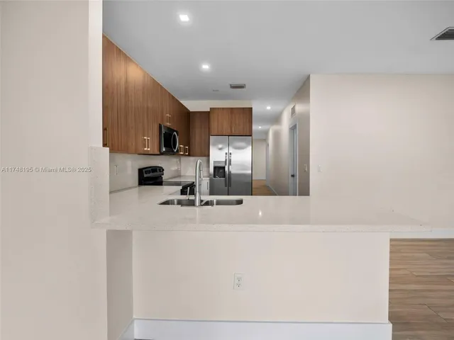 a kitchen with a sink appliances and cabinets