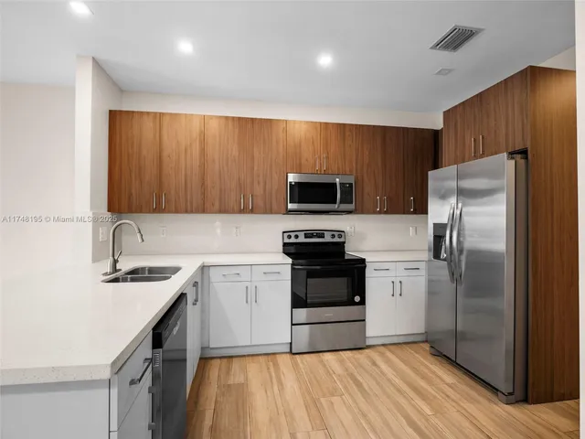 a kitchen with sink a microwave and cabinets