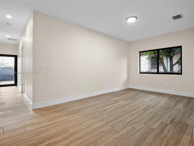 a view of an empty room with wooden floor