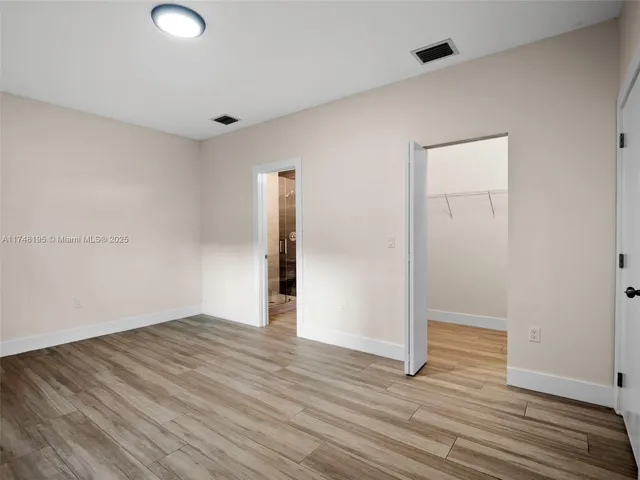 a view of a room that has wooden floor and a window