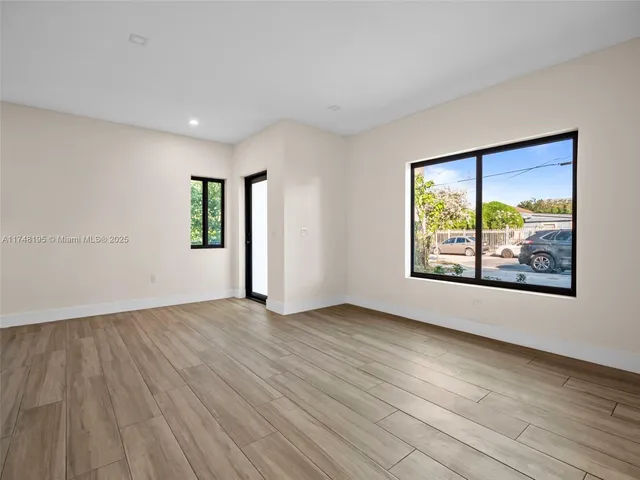 a kitchen with stainless steel appliances granite countertop a refrigerator a stove top oven a sink and dishwasher with wooden floor