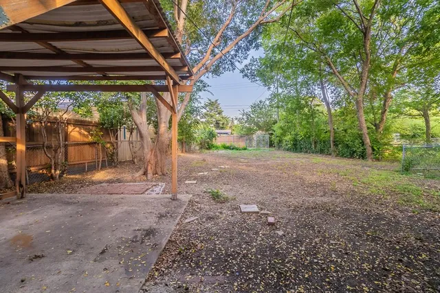 a view of a backyard with large trees