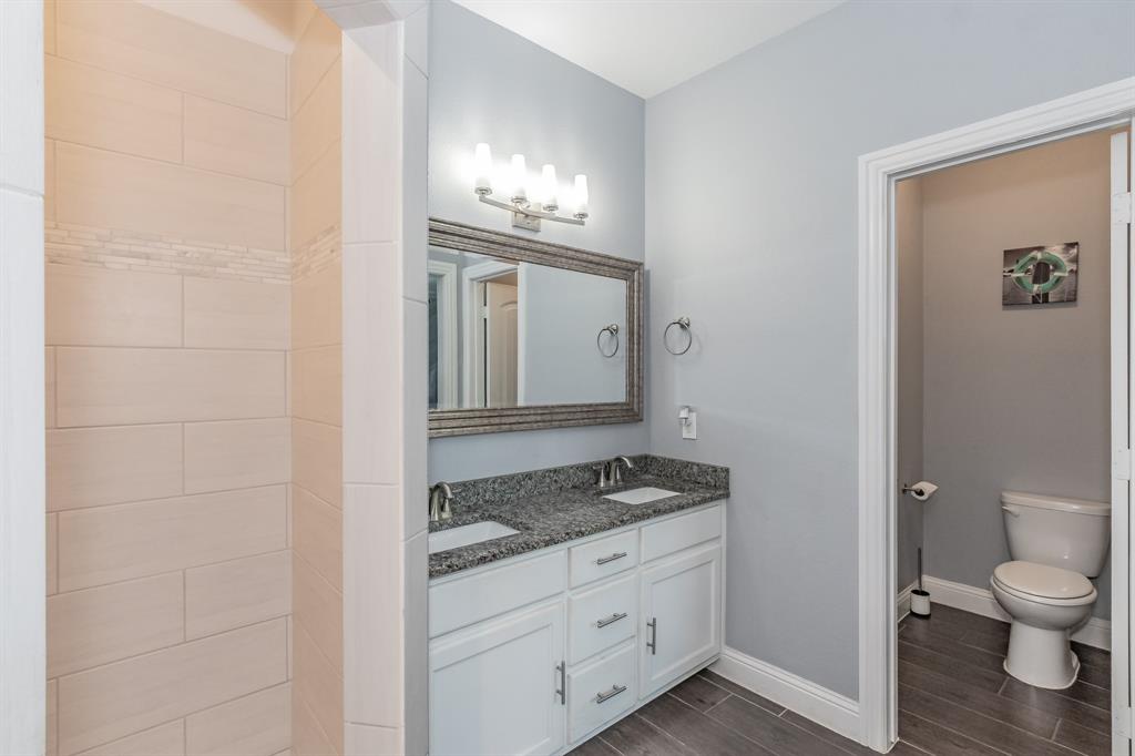 1818 Ebbtide Lane Dallas, TX 75224 - Photo 25 of 33 a bathroom with a granite countertop toilet and a sink