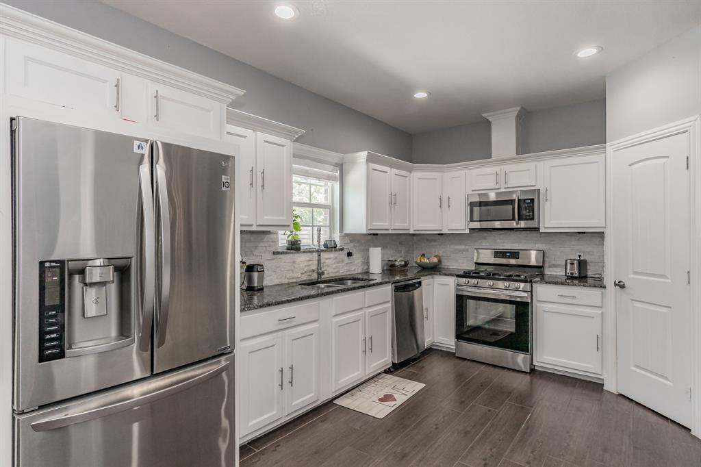 1818 Ebbtide Lane Dallas, TX 75224 - Photo 9 of 33 a kitchen with stainless steel appliances granite countertop a refrigerator stove and sink