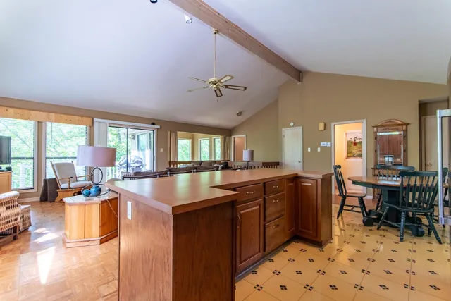 a large kitchen with kitchen island a large counter space windows and a view of dining table