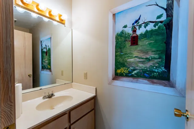 a bathroom with a sink and mirror with window