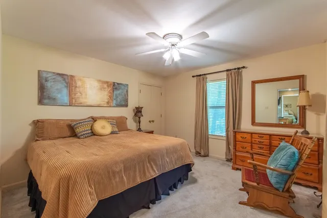 a bedroom with a bed a chair and glass door
