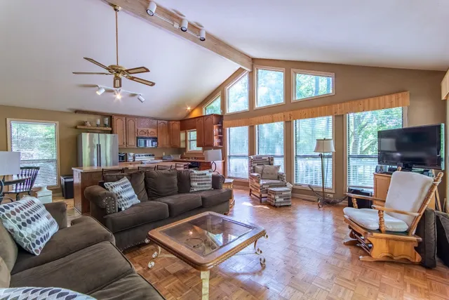 a living room with furniture ceiling fan and a large window