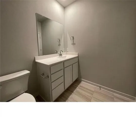 an empty room with chandelier fan and windows