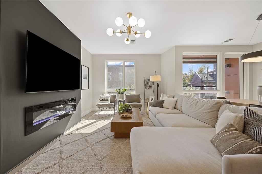 3725 Butler Street, Unit 302 Pittsburgh, PA 15201 - Photo 15 of 44 a living room with furniture a flat screen tv and a chandelier