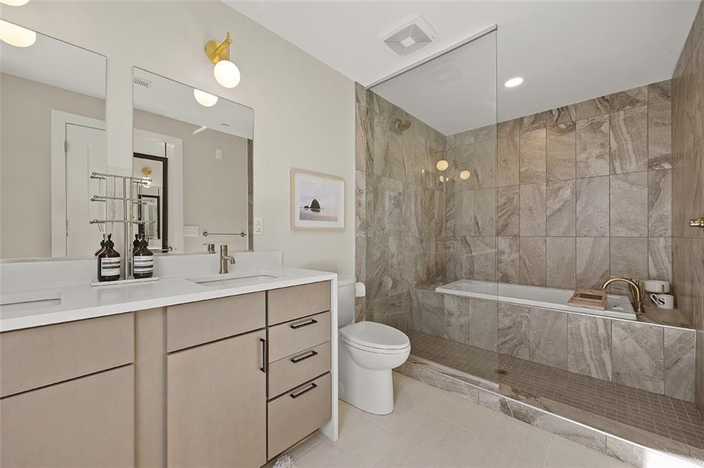 3725 Butler Street, Unit 302 Pittsburgh, PA 15201 - Photo 28 of 44 a bathroom with a sink a toilet and a large mirror