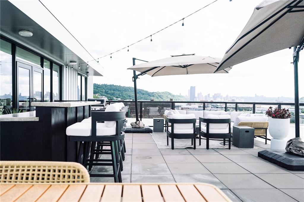 3725 Butler Street, Unit 302 Pittsburgh, PA 15201 - Photo 38 of 44 a view of a patio with a dining table and chairs with wooden floor
