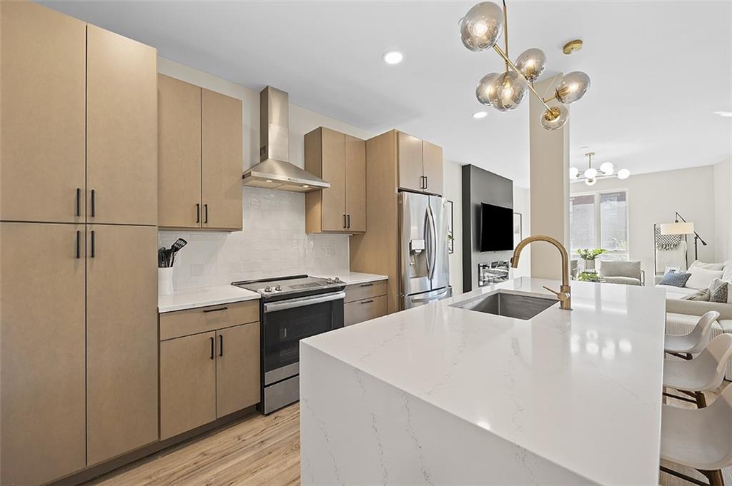 3725 Butler Street, Unit 302 Pittsburgh, PA 15201 - Photo 8 of 44 a kitchen with stainless steel appliances kitchen island a refrigerator sink and fireplace