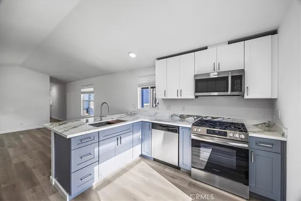 a kitchen with stainless steel appliances granite countertop a stove a sink and a microwave