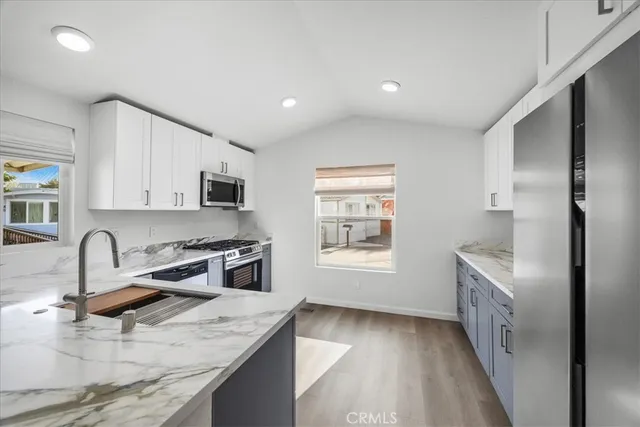 a kitchen with granite countertop a sink stove and refrigerator