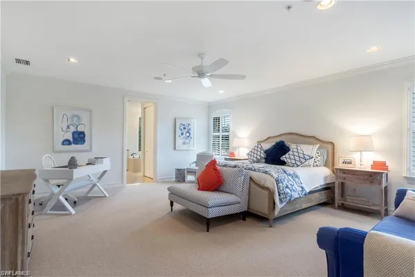 a spacious bedroom with a bed couch and window