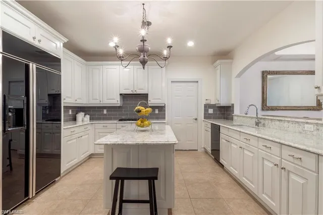 a kitchen with a sink dishwasher a refrigerator a stove and white cabinets with wooden floor