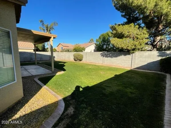 a view of a backyard with table and chairs under an umbrella
