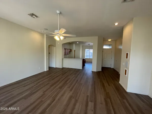 a view of a hallway with wooden floor and a chandelier