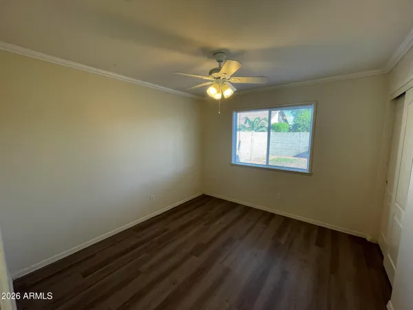 an empty room with windows and fan