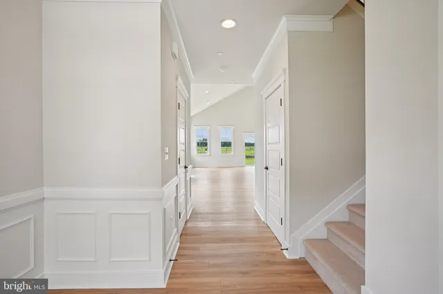 a view of a hallway with wooden floor and staircase