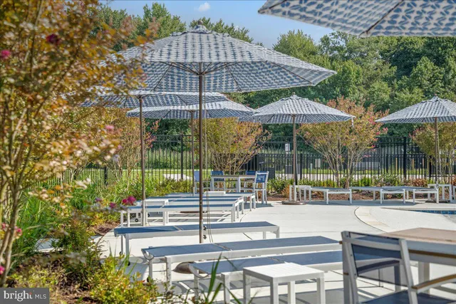 a view of a swimming pool with a table and chairs under an umbrella