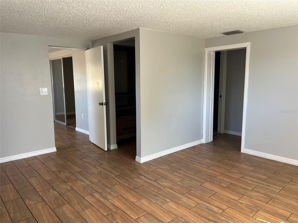 7835 Arbordale Drive Port Richey, FL 34668 - Photo 11 of 21 an empty room with wooden floor and closet