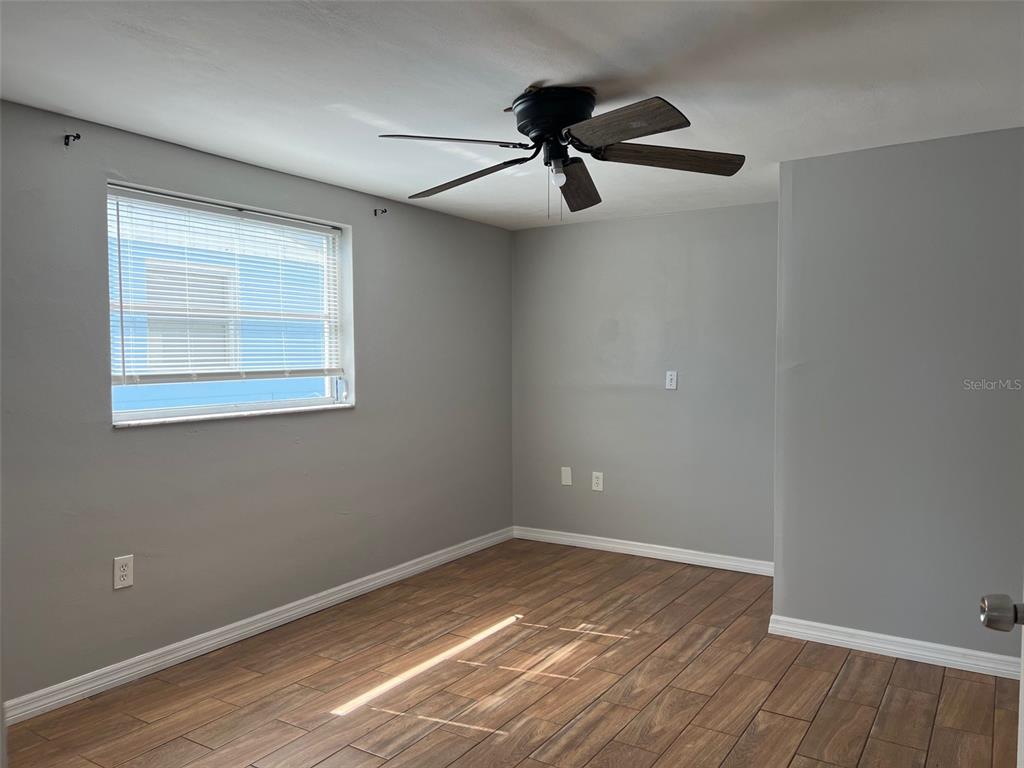 7835 Arbordale Drive Port Richey, FL 34668 - Photo 15 of 21 a view of an empty room with wooden floor and a window