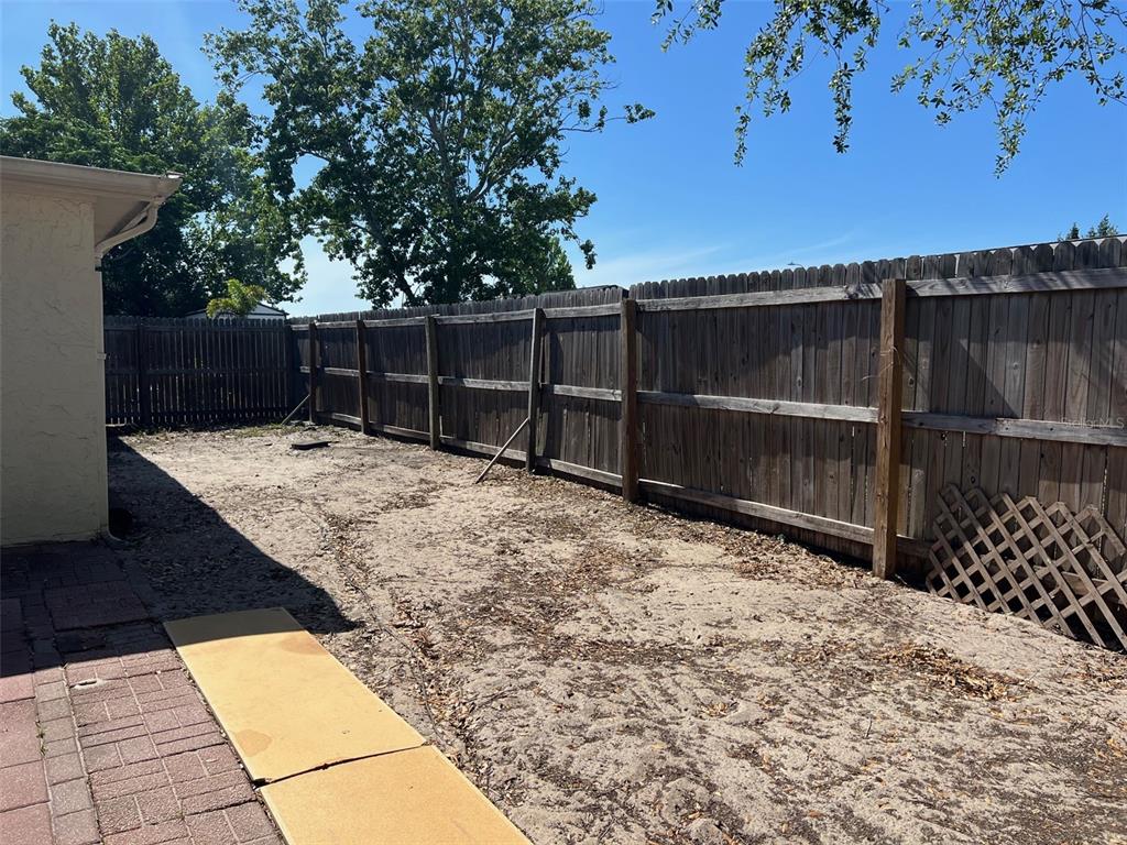 7835 Arbordale Drive Port Richey, FL 34668 - Photo 4 of 21 a backyard of a house with wooden fence