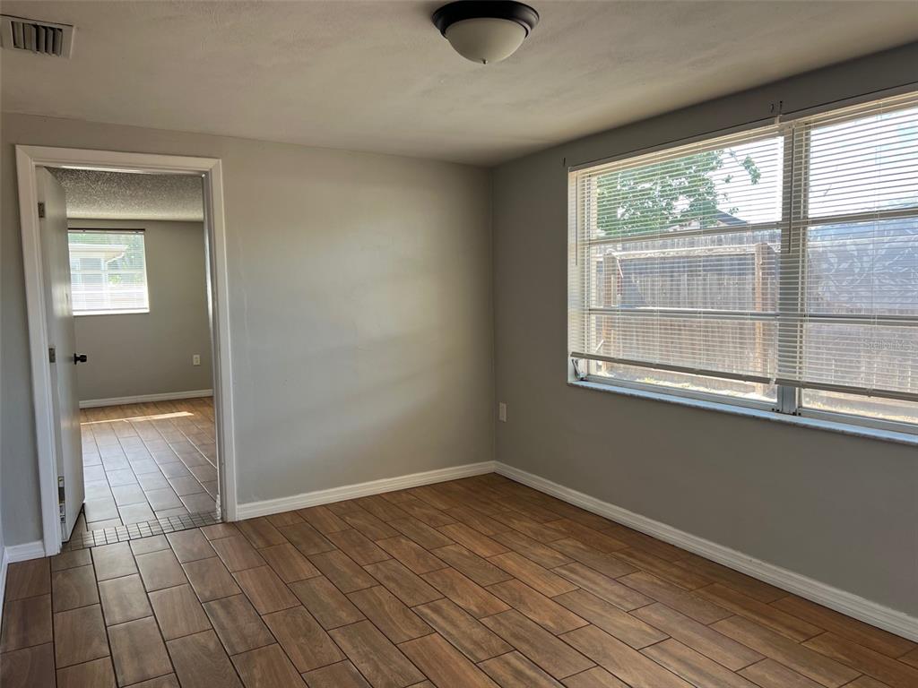 7835 Arbordale Drive Port Richey, FL 34668 - Photo 8 of 21 an empty room with wooden floor and windows