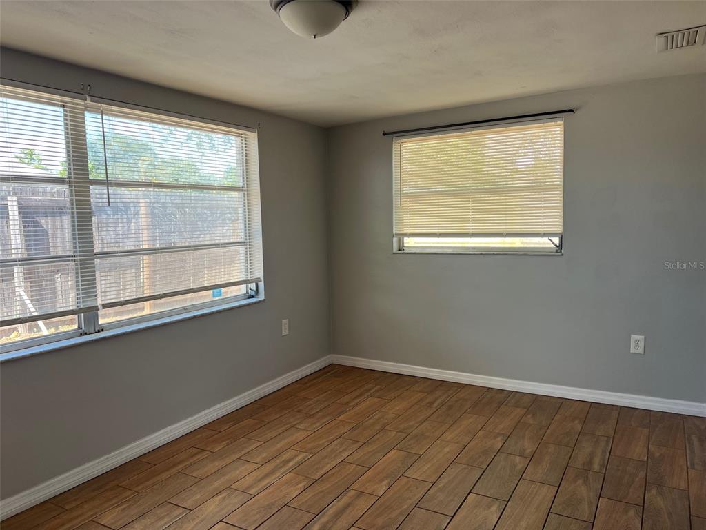 7835 Arbordale Drive Port Richey, FL 34668 - Photo 9 of 21 a view of an empty room with wooden floor and a window