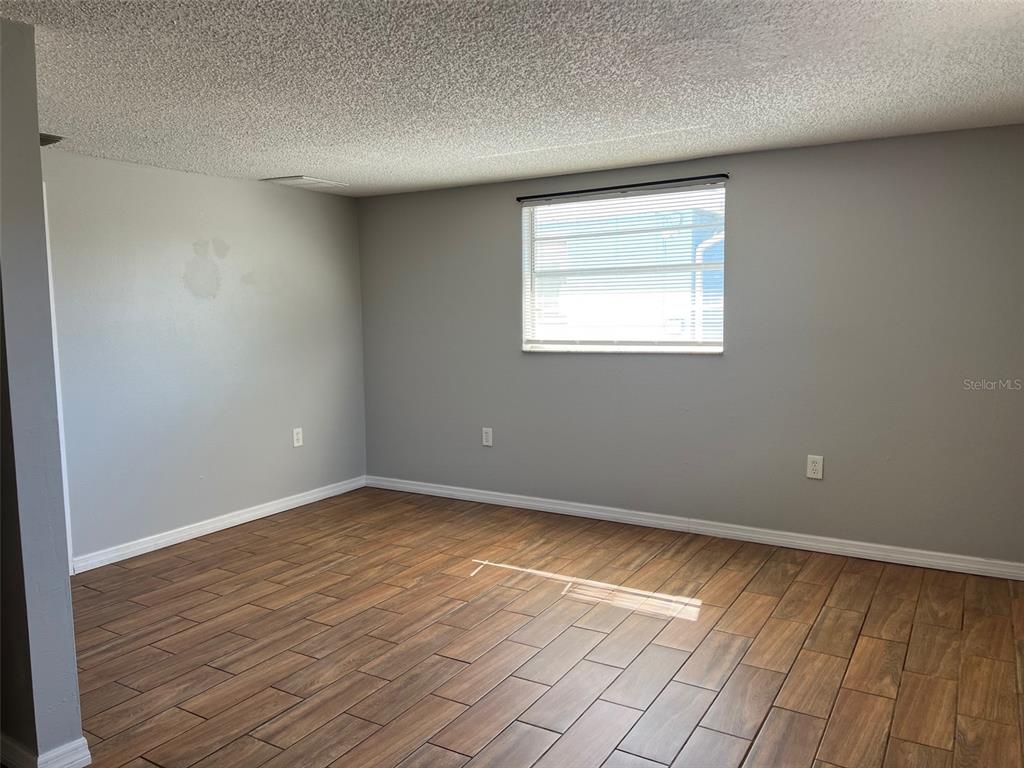 7835 Arbordale Drive Port Richey, FL 34668 - Photo 10 of 21 an empty room with wooden floor and windows