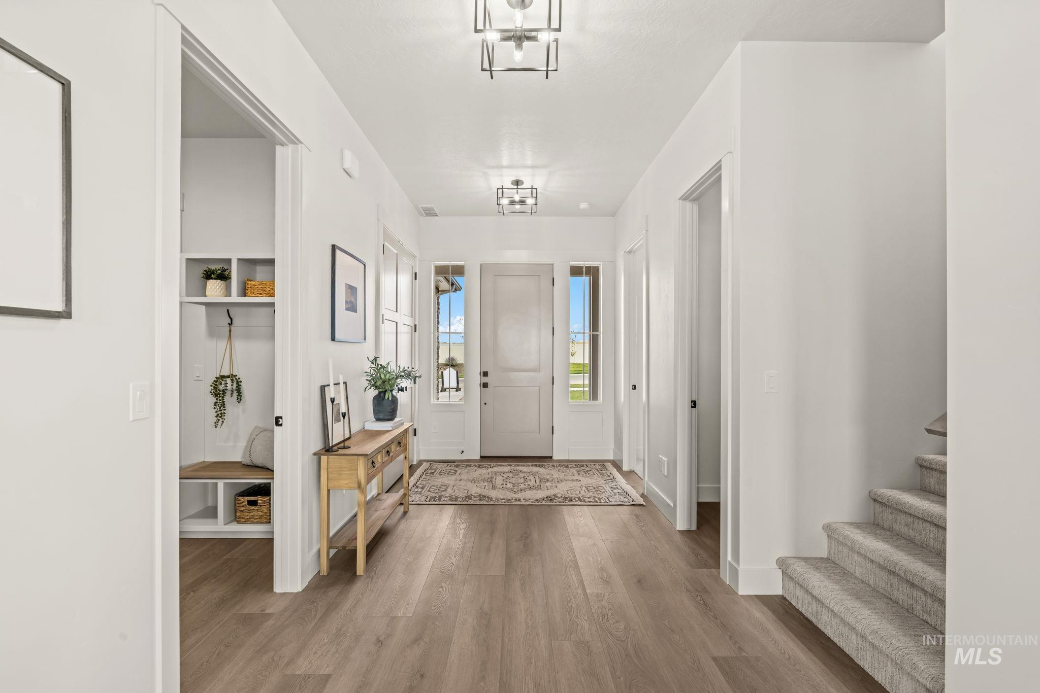 345 South Strut Way Boise, ID 83716 - Photo 4 of 50 Entryway featuring wood-finish flooring, two modern flush-mount light fixtures, and a built-in mudroom bench with shelving