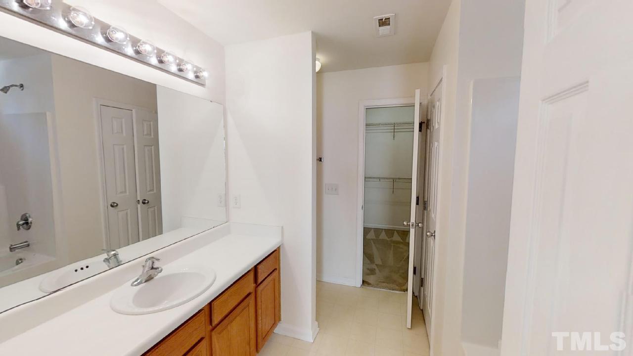 3636 Rendition Street Raleigh, NC 27610 - Photo 14 of 25 a bathroom with a double vanity sink and a mirror