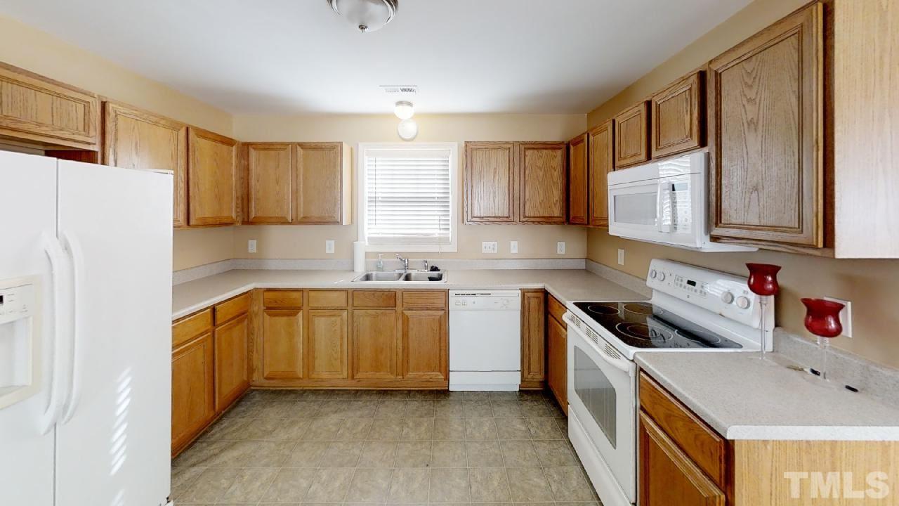 3636 Rendition Street Raleigh, NC 27610 - Photo 8 of 25 a kitchen with stainless steel appliances granite countertop a sink stove and refrigerator