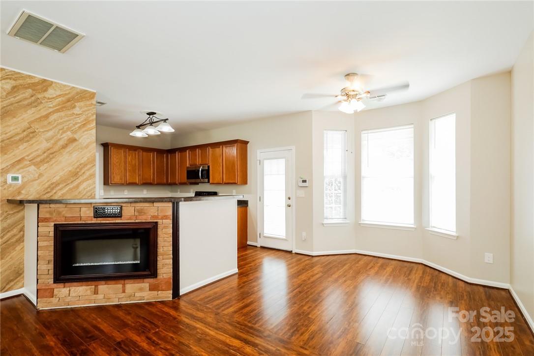 733 Jones Branch Road Fort Mill, SC 29715 - Photo 5 of 15 a view of a livingroom with a fireplace a ceiling fan and wooden floor