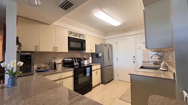 a kitchen with stainless steel appliances granite countertop a refrigerator stove top oven a sink and dishwasher