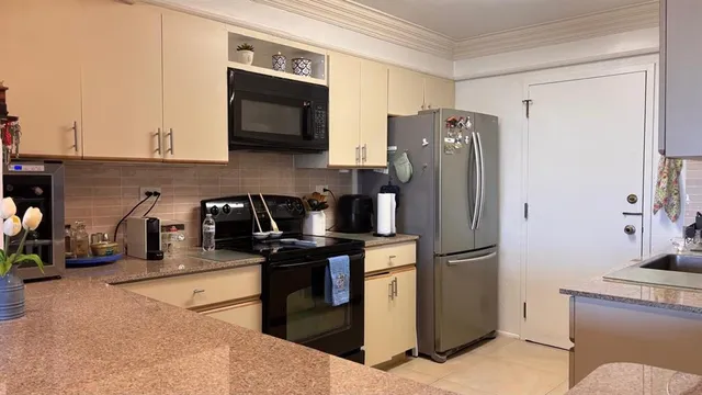 a kitchen with stainless steel appliances granite countertop a refrigerator stove and microwave
