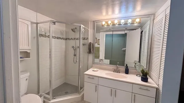a bathroom with a shower a sink and mirror